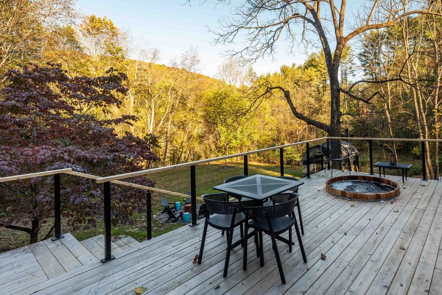 Deck with outdoor dining table, cedar hot tub and fall trees
