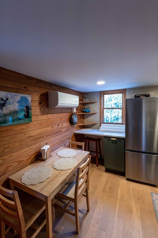 Wood dining table for four against a pine wall