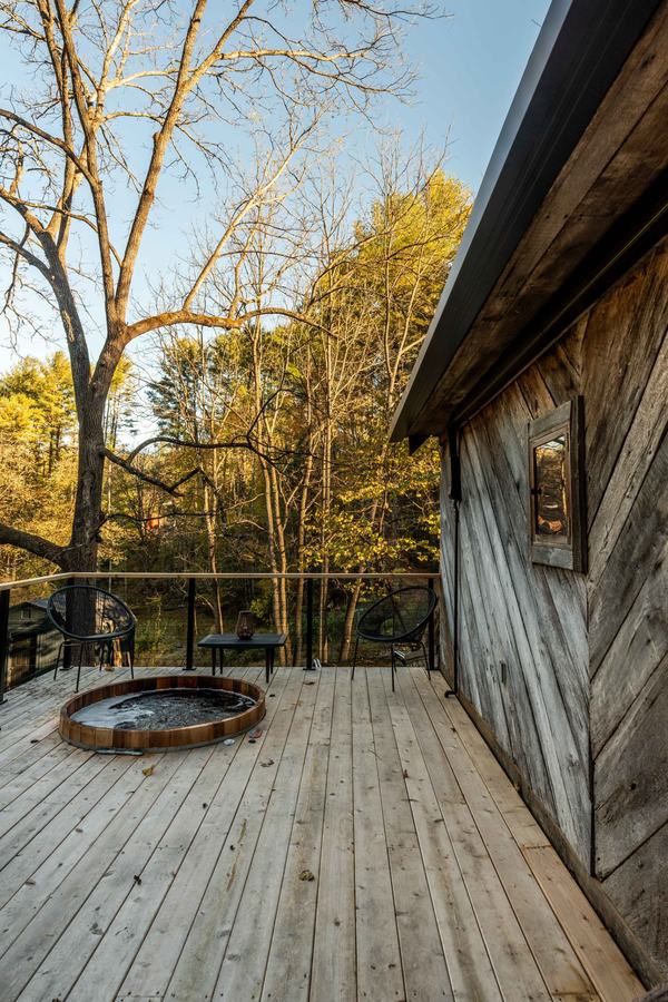 Cedar hot tub on the deck beside the weathered barn siding